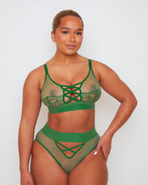 Front view of the Abigail lingerie set in Amazon Green, showcasing a sheer mesh bralette with lace-trimmed cups and criss-cross strap detailing, paired with a high-waisted brief featuring sheer polka-dot mesh panels and decorative strappy accents.