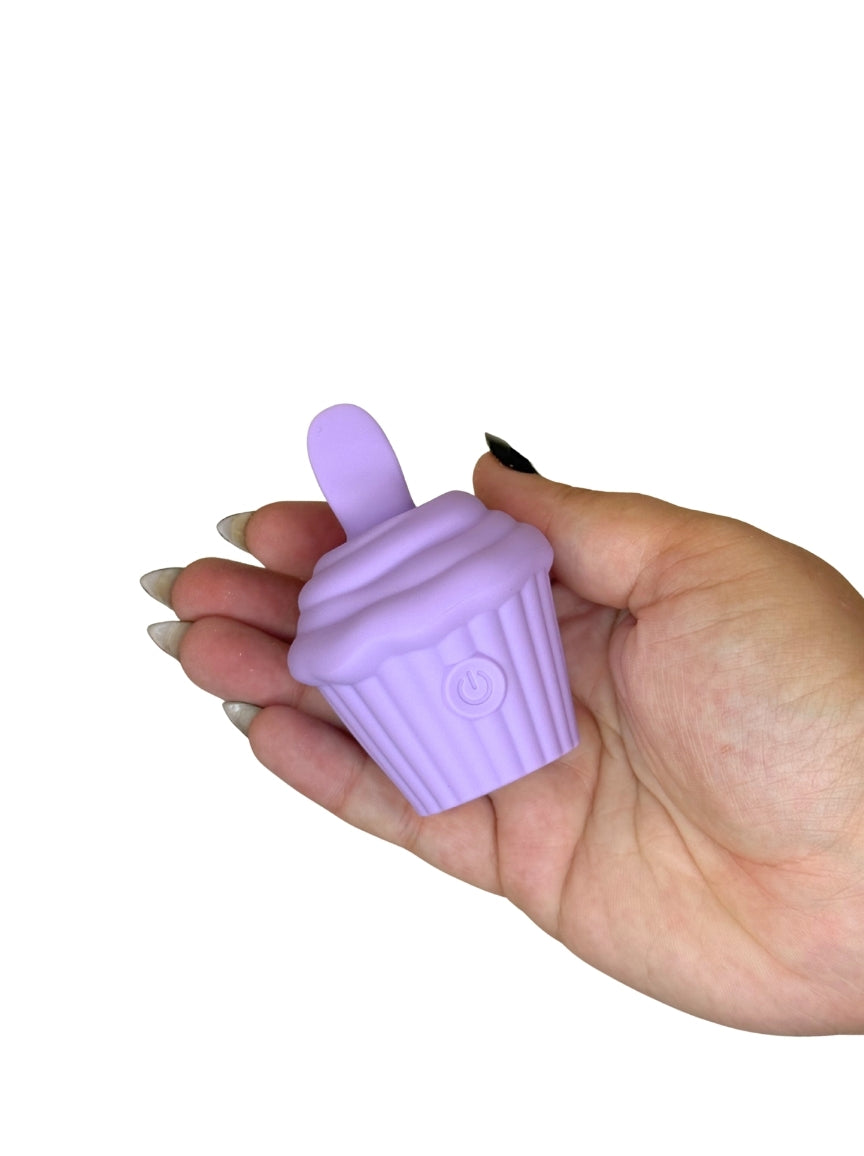 Hand holding a purple silicone cupcake-shaped item against a white background