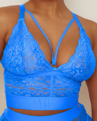 Blue lace bralette worn by a person against a neutral background