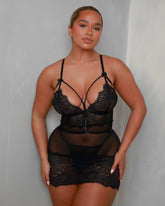 Front view of the Tutti Boudoir Kanika Dress in Onyx Black, featuring sheer mesh, soft floral lace cups, elegant strap detailing across the neckline and a figure-skimming silhouette designed to celebrate your curves.