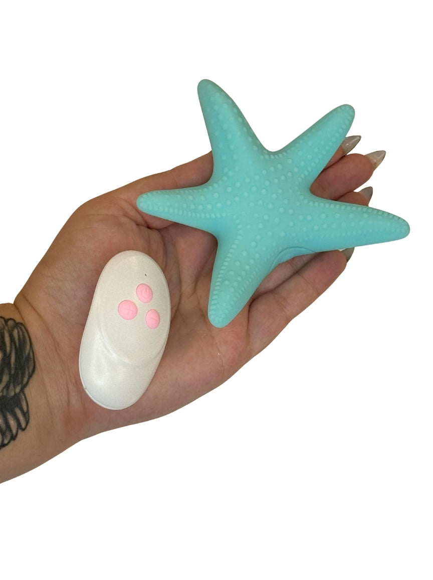Hand holding a turquoise star-shaped object against a white background