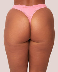 Person wearing pink lace underwear on a plain background