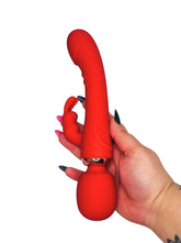 Red silicone personal massager adult toy held by a hand with black nail polish on a white background