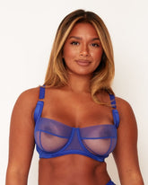 Woman wearing a blue bra against a white background