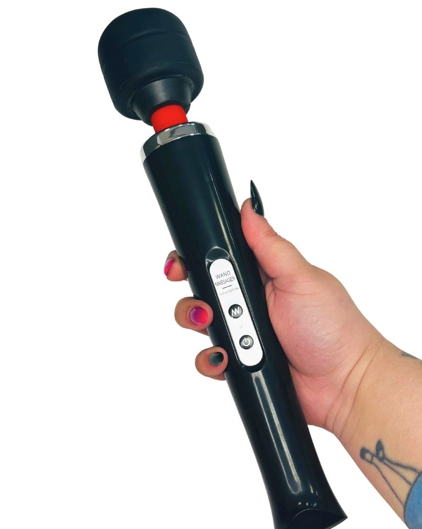 Hand holding a black personal massager wand with a white background