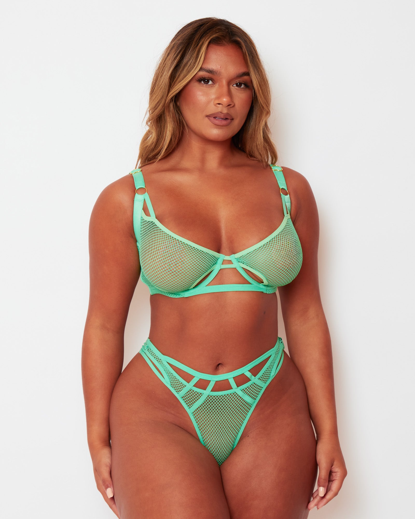 Front view of the Tutti Rouge Aphrodite Apple Green fishnet bra and thong set with cut-out detailing and gold-tone hardware.