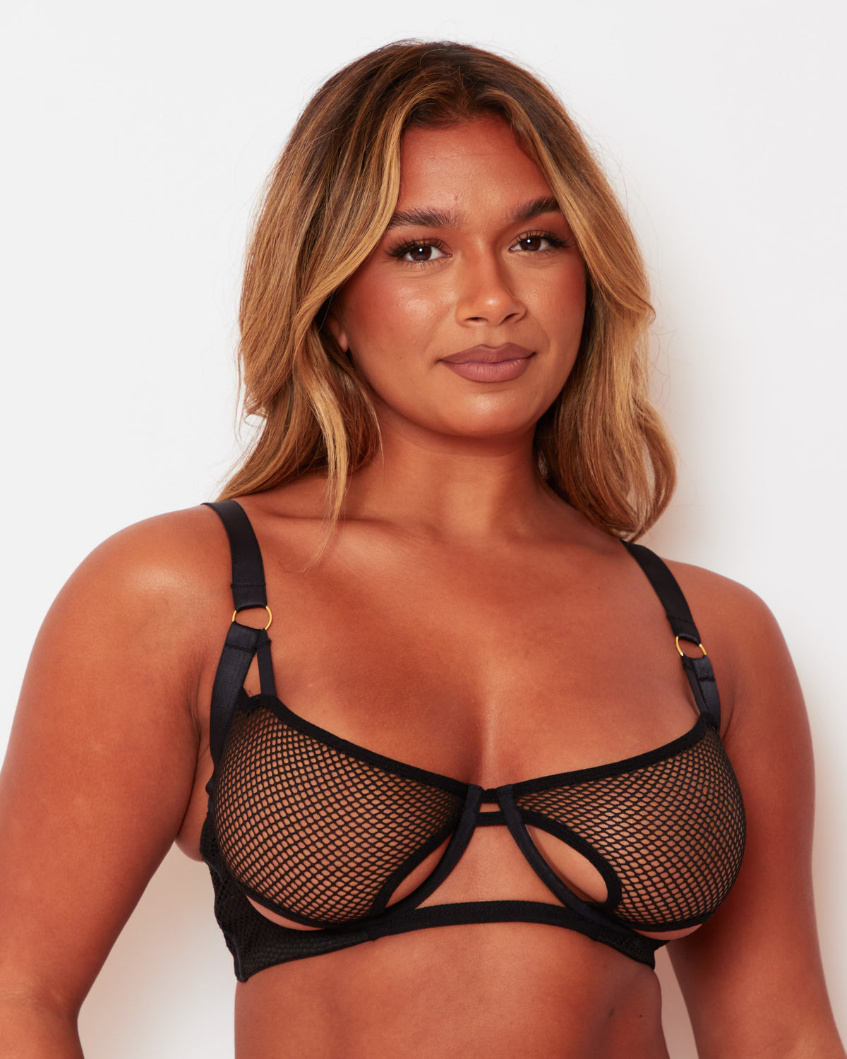 Front close-up of the Tutti Rouge Aphrodite black bra with fishnet cups, cut-out detailing and gold-tone strap rings.