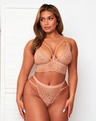Model wearing the Tutti Rouge Aria Warm Sand bralette and thong, showing floral lace and a strappy plunge neckline.