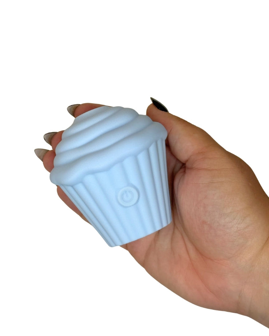 Hand holding a light blue cupcake-shaped object against a white background