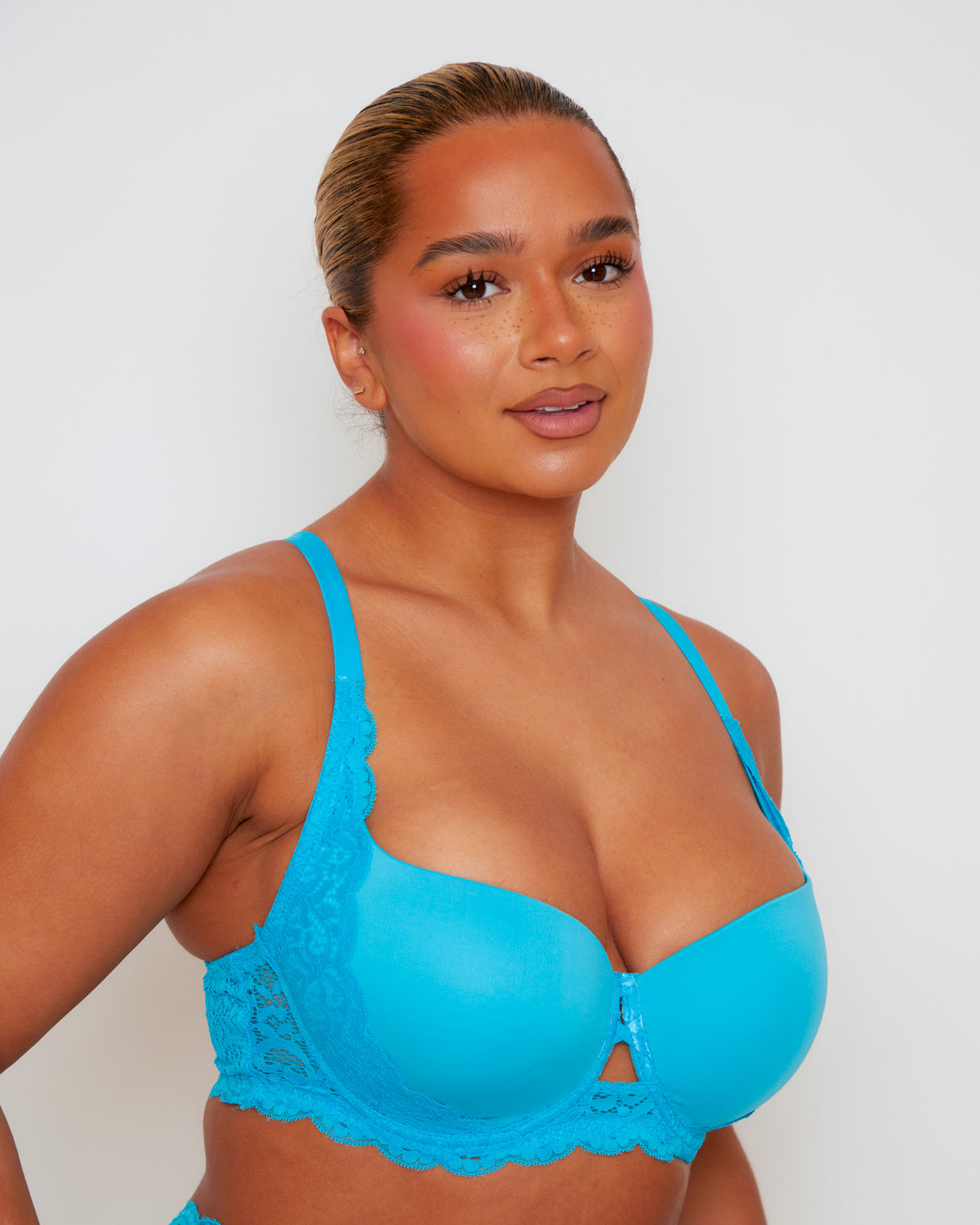 Close-up of Tutti Rouge Daley Lace bra in Bluebird Blue on a model, showing smooth moulded cups, scalloped lace and centre cut-out.