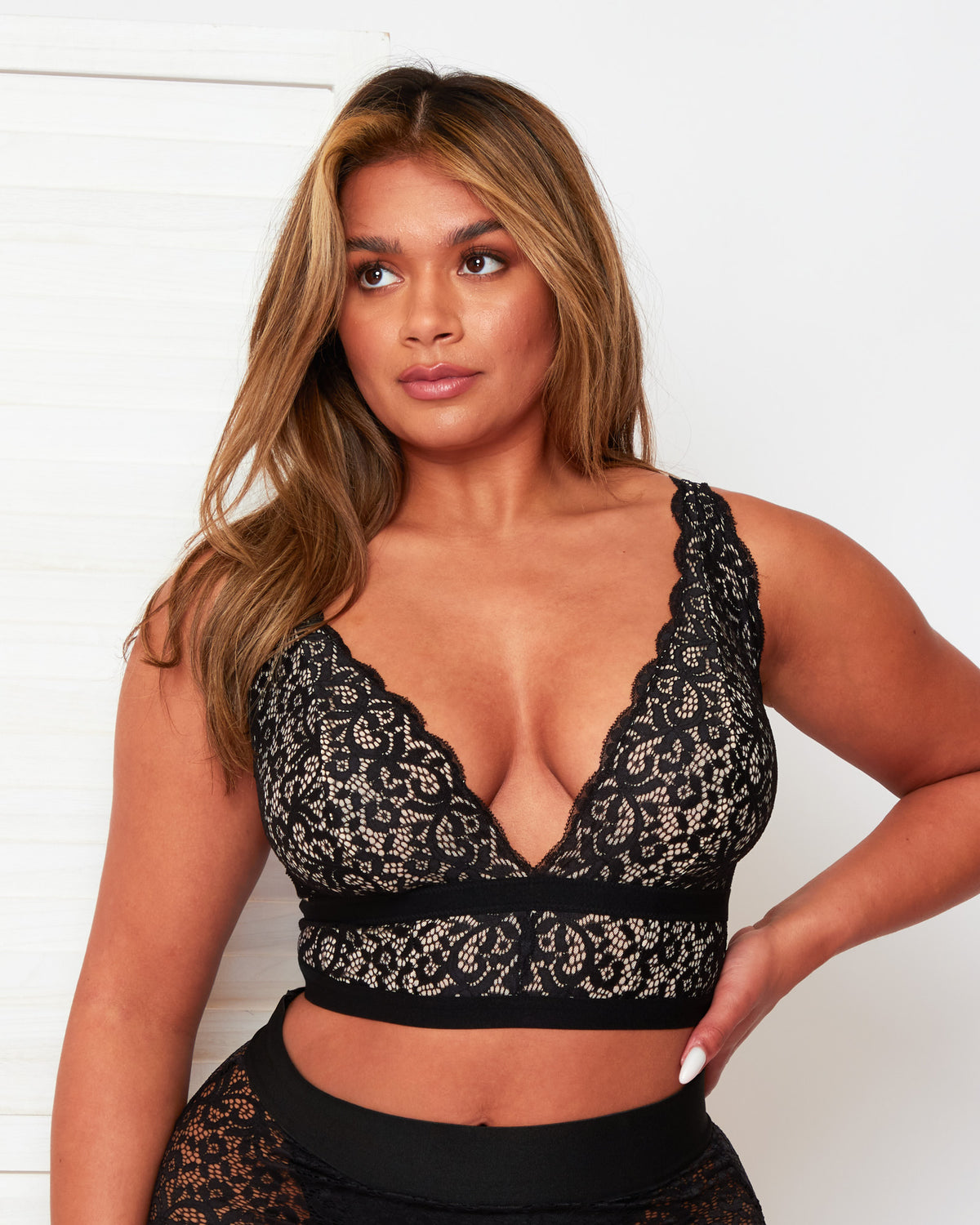 Model wearing the Tutti Rouge Eden Midnight Black lace bralette with a scalloped plunge neckline and longline lace underband.