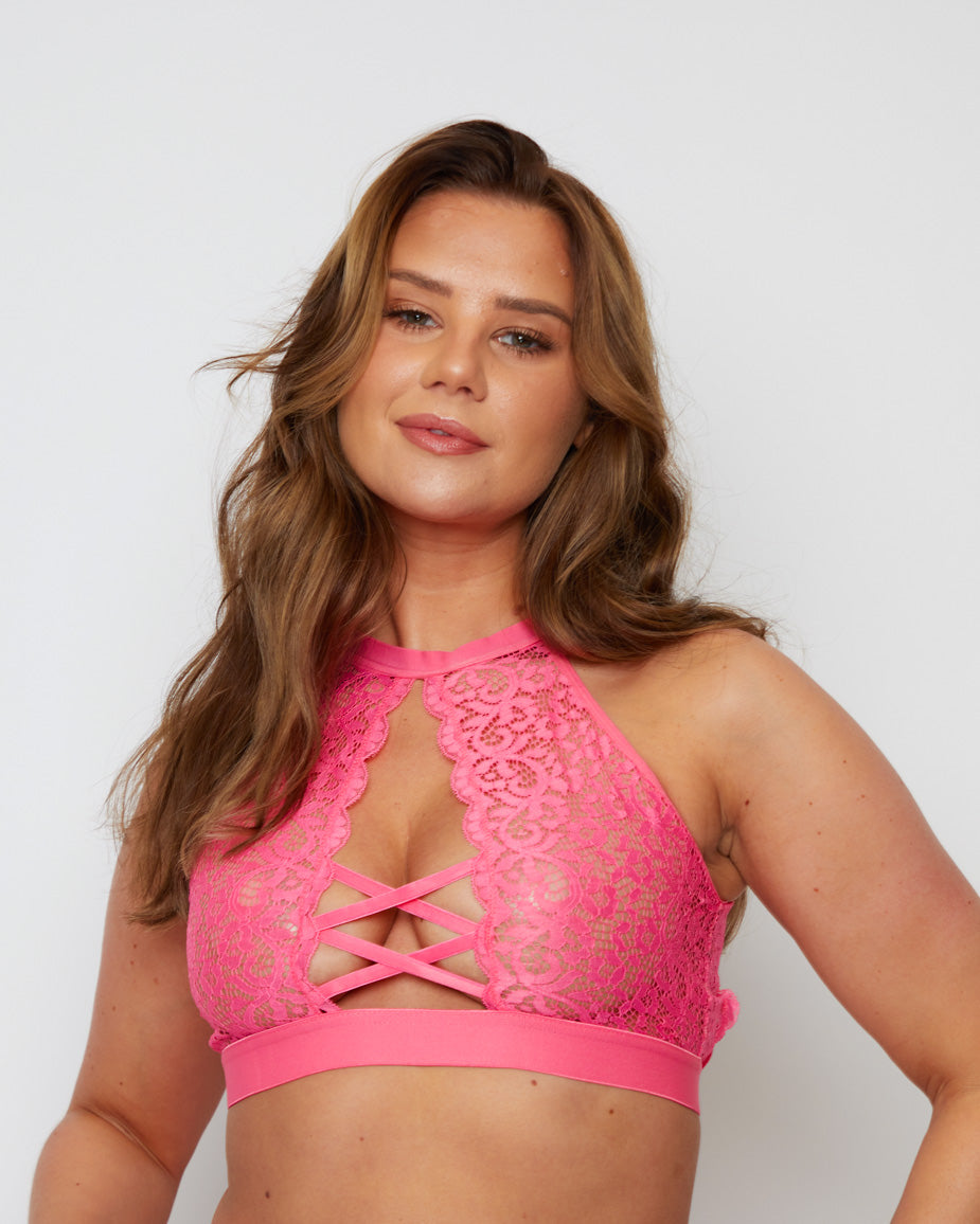 Close-up of the Elektra Bralette in Rose Pink, showcasing the intricate floral lace, elegant high neckline, and eye-catching criss-cross front straps that create a confident, feminine look.