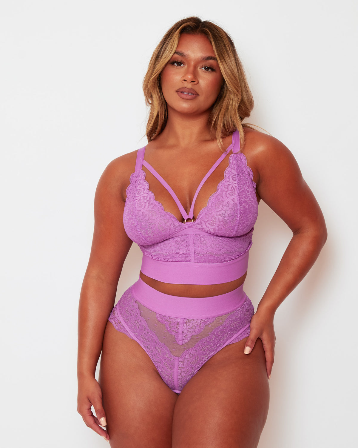 Model wearing the Tutti Rouge Gia Pillow Purple lace bralette and matching thong with a strappy plunge neckline and wide bands.