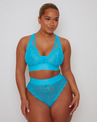 Front view of a model wearing the Hallie Bralette and Brief in Bluebird Blue, featuring floral stretch lace, sheer mesh accents, a supportive wide underband, and a high-waisted lace brief with scalloped edges.