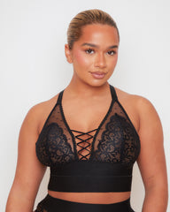 Front close-up of the Tutti Rouge Maya Bralette in Midnight Black featuring soft floral lace, sheer dotted mesh, a plunging neckline and signature lace-up front detail.