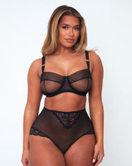 Front view of model wearing Tutti Rouge Raya black underwired balcony bra and high-waisted black mesh briefs with floral lace panels.