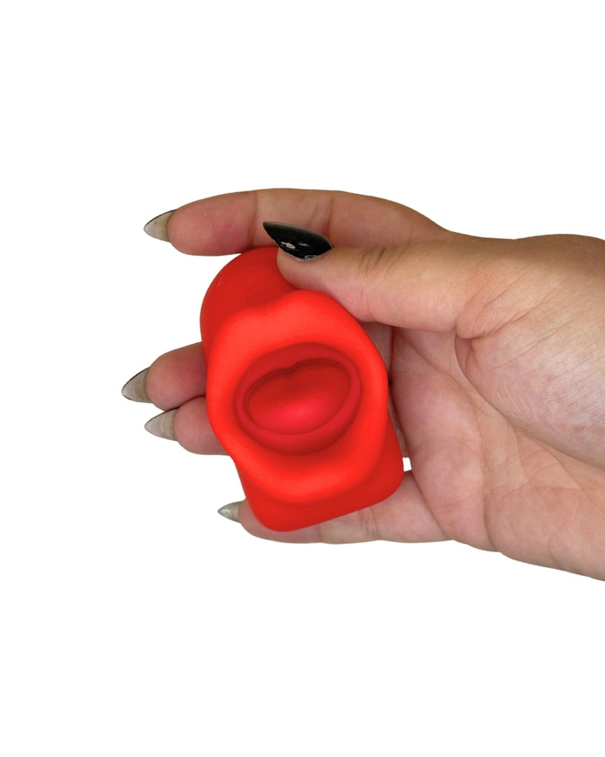 Hand holding a red object against a white background
