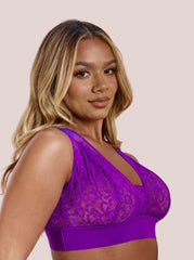 Woman wearing a purple lace bralette against a beige background