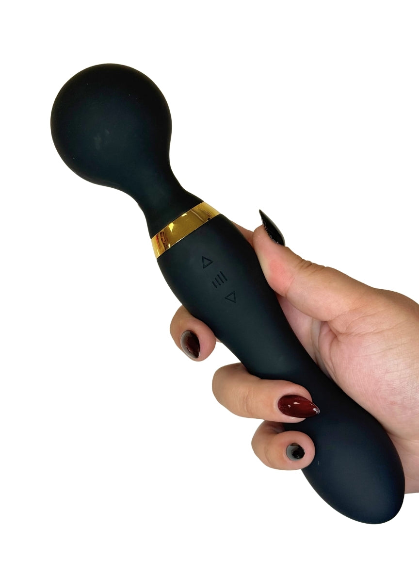 Black handheld device with gold accent held by a hand on a white background